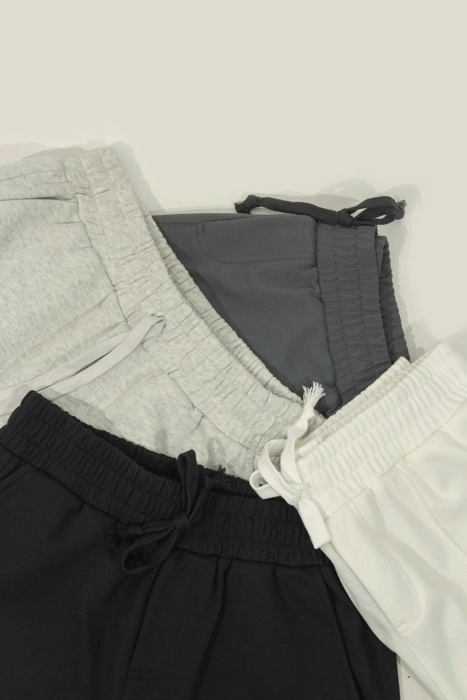 Fleece and twill drawstring shorts in heather grey, charcoal, black and white laid flat
