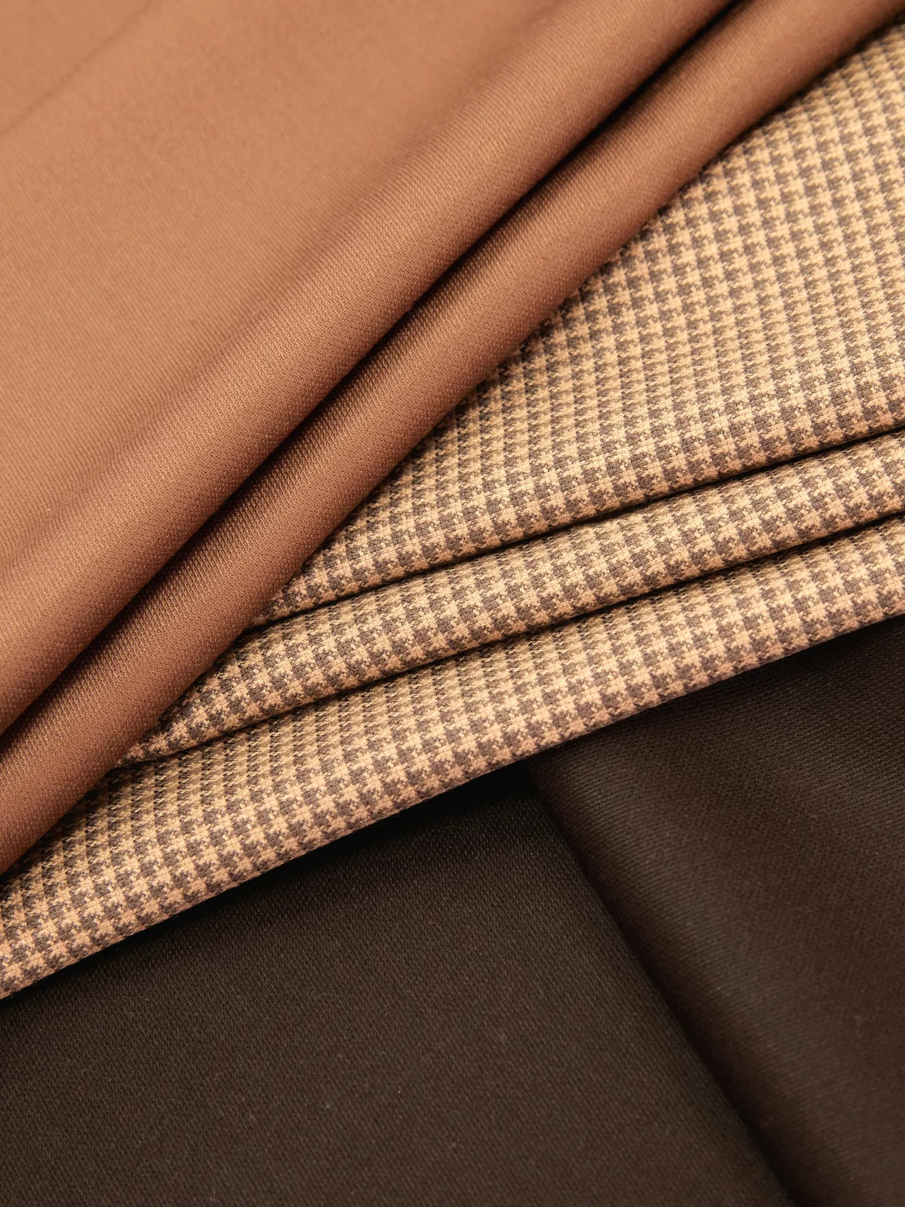 Folded fabrics in rust cotton, tan micro-houndstooth and chocolate brown